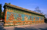 The Nine Dragon Screen, dating back to 1417, is an 87-foot wall decorated with glazed tiles showing nine dragons chasing a pearl in clouds above waves.