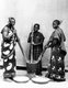 Tanzania / Zanzibar: Studio portrait of three Swahili women pounding maize, c. 1910